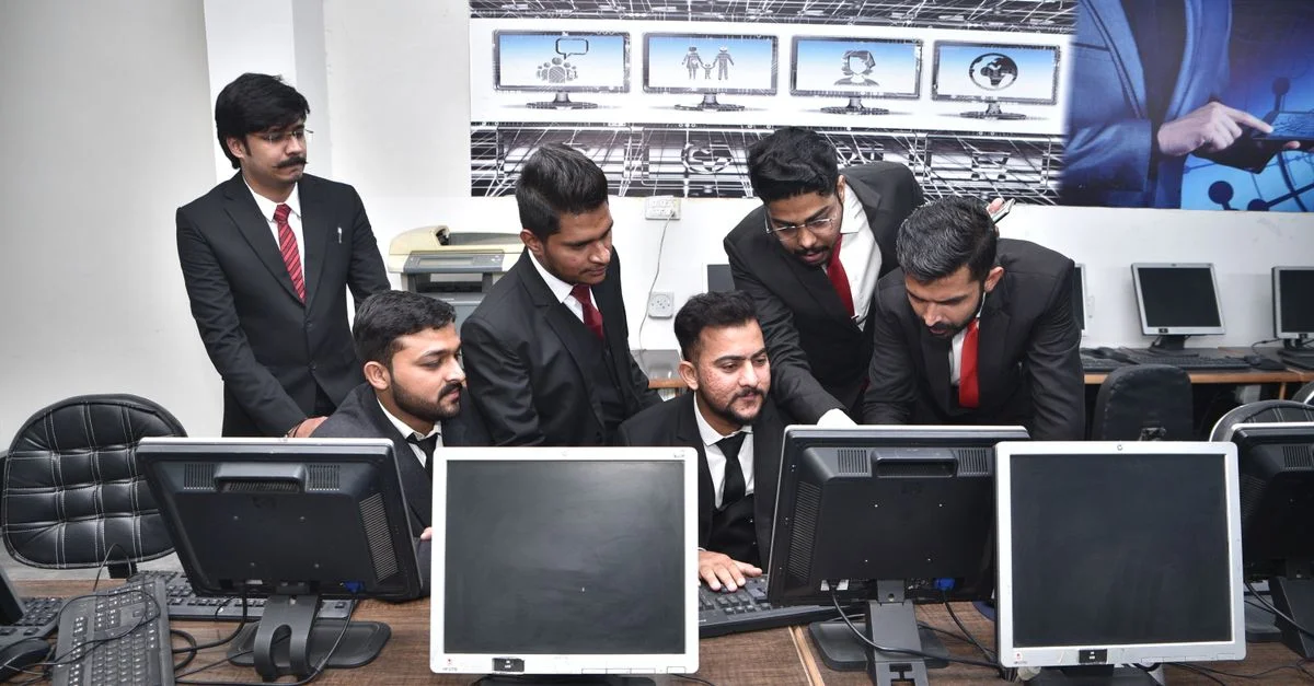 Groupe de professionnels collaborant sur un travail informatique dans un bureau moderne.